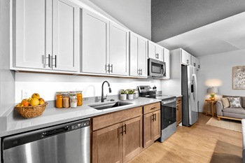 A modern kitchen with wooden cabinets and stainless steel appliances.at Plant 1 Lofts, Iowa, 50208